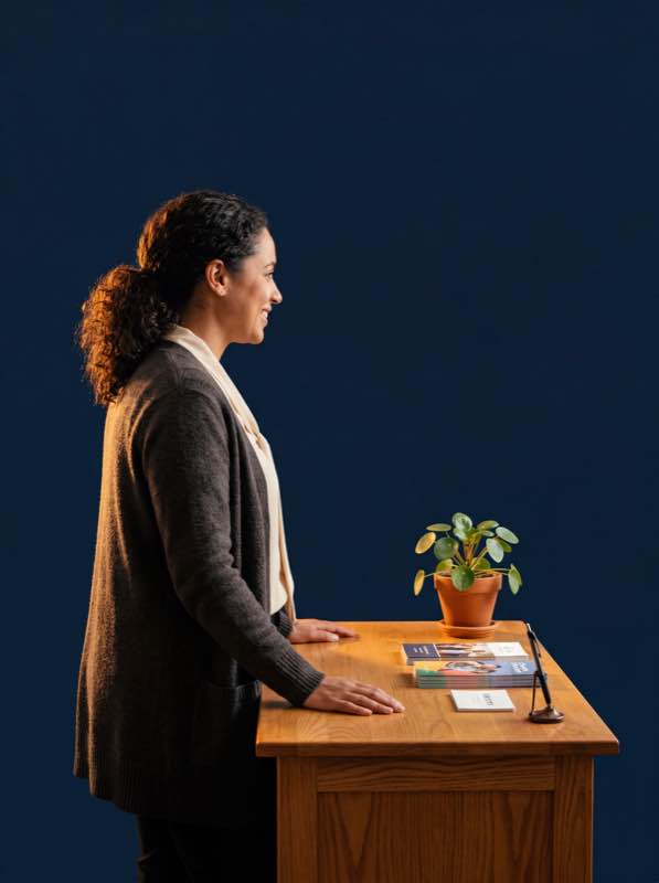 Church staff member at warm wooden welcome desk