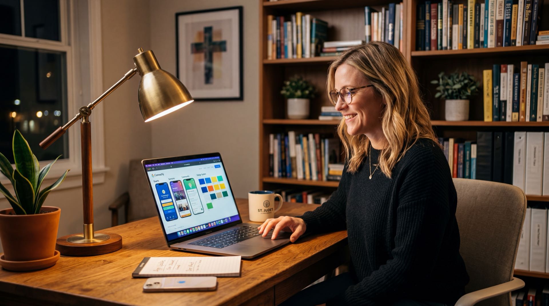 Church admin at modern desk designing app on laptop
